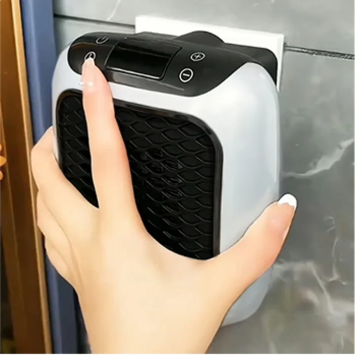 Hand using the top controls on a compact WellHeater plug-in heater