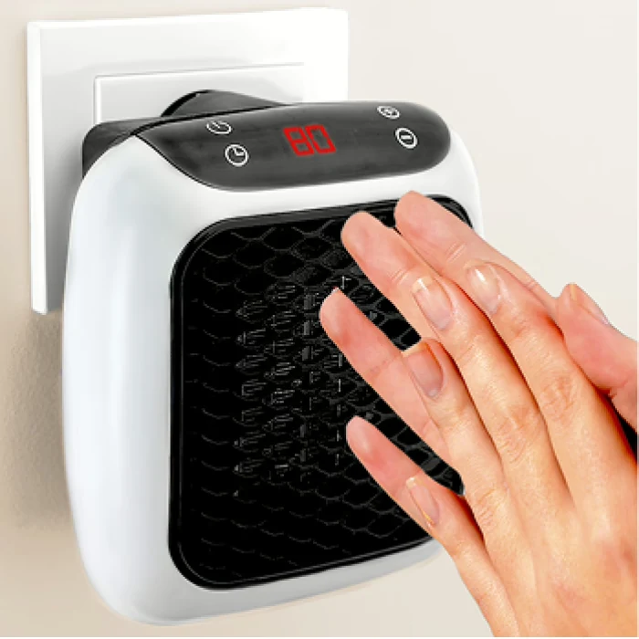 Hand feeling warmth near a compact WellHeater plug-in heater